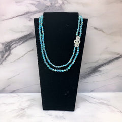 Vintage double‑strand aqua blue AB crystal necklace with faceted beads and a silver‑tone pavé rhinestone brooch clasp, shown from multiple angles to highlight bead size, sparkle, and clasp detailing.