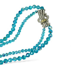 Vintage double‑strand aqua blue AB crystal necklace with faceted beads and a silver‑tone pavé rhinestone brooch clasp, shown from multiple angles to highlight bead size, sparkle, and clasp detailing.