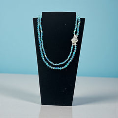 Vintage double‑strand aqua blue AB crystal necklace with faceted beads and a silver‑tone pavé rhinestone brooch clasp, shown from multiple angles to highlight bead size, sparkle, and clasp detailing.