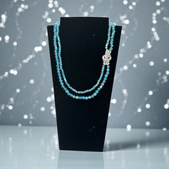 Vintage double‑strand aqua blue AB crystal necklace with faceted beads and a silver‑tone pavé rhinestone brooch clasp, shown from multiple angles to highlight bead size, sparkle, and clasp detailing.