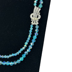 Vintage double‑strand aqua blue AB crystal necklace with faceted beads and a silver‑tone pavé rhinestone brooch clasp, shown from multiple angles to highlight bead size, sparkle, and clasp detailing.