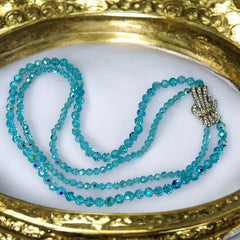 Vintage double‑strand aqua blue AB crystal necklace with faceted beads and a silver‑tone pavé rhinestone brooch clasp, shown from multiple angles to highlight bead size, sparkle, and clasp detailing.
