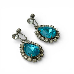 A pair of vintage 1950s–60s silver‑tone screw‑back earrings with aqua pear rhinestones and clear accent stones, shown from different angles to highlight their shape and condition.