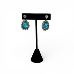 A pair of vintage 1950s–60s silver‑tone screw‑back earrings with aqua pear rhinestones and clear accent stones, shown from different angles to highlight their shape and condition.