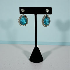 A pair of vintage 1950s–60s silver‑tone screw‑back earrings with aqua pear rhinestones and clear accent stones, shown from different angles to highlight their shape and condition.