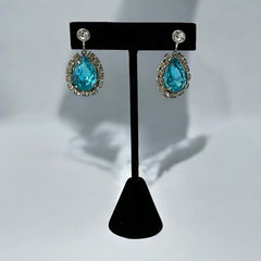 A pair of vintage 1950s–60s silver‑tone screw‑back earrings with aqua pear rhinestones and clear accent stones, shown from different angles to highlight their shape and condition.