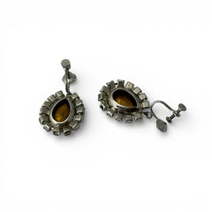 A pair of vintage 1950s–60s silver‑tone screw‑back earrings with aqua pear rhinestones and clear accent stones, shown from different angles to highlight their shape and condition.