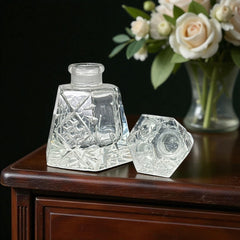 Vintage Czech hand-cut glass perfume bottle with faceted hexagon base and original stopper, shown in varied lighting to highlight its Art Deco silhouette and reflective clarity.