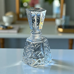 Vintage Czech hand-cut glass perfume bottle with faceted hexagon base and original stopper, shown in varied lighting to highlight its Art Deco silhouette and reflective clarity.