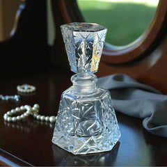 Vintage Czech hand-cut glass perfume bottle with faceted hexagon base and original stopper, shown in varied lighting to highlight its Art Deco silhouette and reflective clarity.