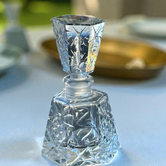 Vintage Czech hand-cut glass perfume bottle with faceted hexagon base and original stopper, shown in varied lighting to highlight its Art Deco silhouette and reflective clarity.