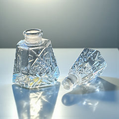 Vintage Czech hand-cut glass perfume bottle with faceted hexagon base and original stopper, shown in varied lighting to highlight its Art Deco silhouette and reflective clarity.