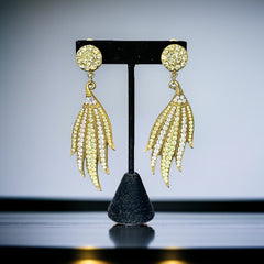 Vintage gold-tone clip-on earrings with jonquil and clear rhinestones in a feather-like Art Deco revival design; long dangle silhouette, 1970s style.