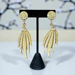 Vintage gold-tone clip-on earrings with jonquil and clear rhinestones in a feather-like Art Deco revival design; long dangle silhouette, 1970s style.