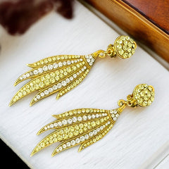 Vintage gold-tone clip-on earrings with jonquil and clear rhinestones in a feather-like Art Deco revival design; long dangle silhouette, 1970s style.