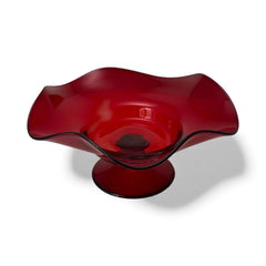 Vintage ruby red hand-blown glass bowl with a freeform wavy rim and clear pedestal base, photographed from above to highlight its organic curves and glossy surface. Midcentury compote style, ideal for decorative or serving use.