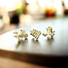 Set of three vintage Asian-themed scatter brooches in white enamel and gold tone, featuring a rickshaw scene, a pagoda, and a man carrying food boxes on a shoulder cane, displayed on a black background.