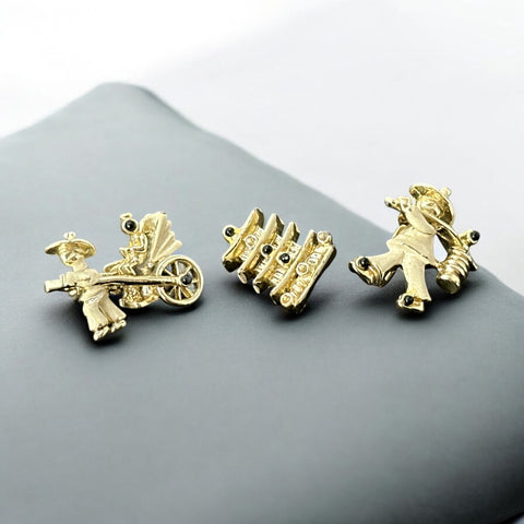 Set of three vintage Asian-themed scatter brooches in white enamel and gold tone, featuring a rickshaw scene, a pagoda, and a man carrying food boxes on a shoulder cane, displayed on a black background.