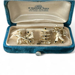 Set of three vintage Asian-themed scatter brooches in white enamel and gold tone, featuring a rickshaw scene, a pagoda, and a man carrying food boxes on a shoulder cane, displayed on a black background.