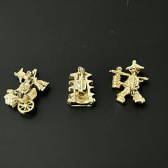 Set of three vintage Asian-themed scatter brooches in white enamel and gold tone, featuring a rickshaw scene, a pagoda, and a man carrying food boxes on a shoulder cane, displayed on a black background.