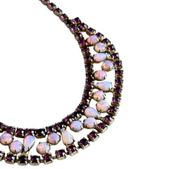 A vintage Astra necklace featuring glowing faux opal cabochons and deep amethyst stones in a double‑row midcentury design, shown on a neutral background to highlight its color and detail.