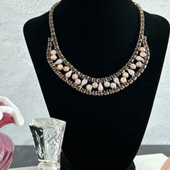 A vintage Astra necklace featuring glowing faux opal cabochons and deep amethyst stones in a double‑row midcentury design, shown on a neutral background to highlight its color and detail.
