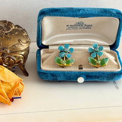 Vintage Austrian blue and green granulated enamel floral clip‑on earrings with rhinestone accents, shown from multiple angles to display their mid‑century design.