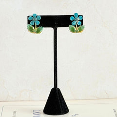 Vintage Austrian blue and green granulated enamel floral clip‑on earrings with rhinestone accents, shown from multiple angles to display their mid‑century design.