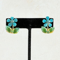 Vintage Austrian blue and green granulated enamel floral clip‑on earrings with rhinestone accents, shown from multiple angles to display their mid‑century design.