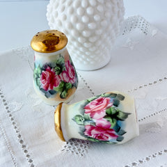 Vintage Austrian porcelain salt and pepper shakers hand‑painted with pink roses and gold tops, shown from multiple angles on a white background.