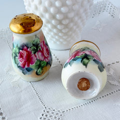 Vintage Austrian porcelain salt and pepper shakers hand‑painted with pink roses and gold tops, shown from multiple angles on a white background.