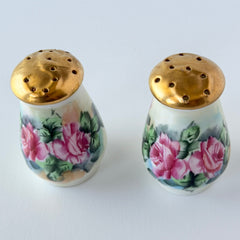 Vintage Austrian porcelain salt and pepper shakers hand‑painted with pink roses and gold tops, shown from multiple angles on a white background.