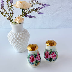 Vintage Austrian porcelain salt and pepper shakers hand‑painted with pink roses and gold tops, shown from multiple angles on a white background.