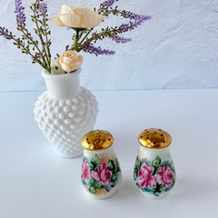 Vintage Austrian porcelain salt and pepper shakers hand‑painted with pink roses and gold tops, shown from multiple angles on a white background.