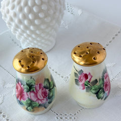 Vintage Austrian porcelain salt and pepper shakers hand‑painted with pink roses and gold tops, shown from multiple angles on a white background.