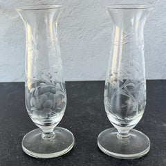 Pair of vintage Avon etched glass pedestal vases with frosted floral design and flared rim.