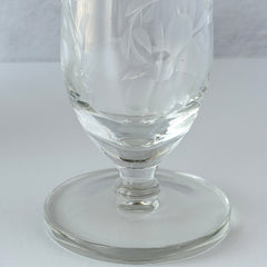 Pair of vintage Avon etched glass pedestal vases with frosted floral design and flared rim.