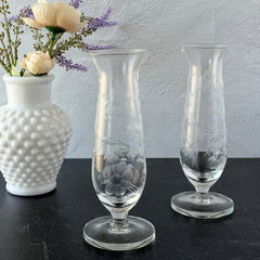 Pair of vintage Avon etched glass pedestal vases with frosted floral design and flared rim.