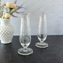 Pair of vintage Avon etched glass pedestal vases with frosted floral design and flared rim.