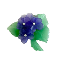 Vintage 1983 Avon brooch with frosted purple resin violets, green leaves, and faux‑pearl centers.