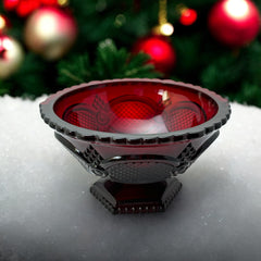 Vintage Avon ruby red glass compote with scalloped rim and pedestal base, featuring embossed Cape Cod pattern and rich crimson hue; a collectible 1970s–1990s candy dish styled for festive tables or vintage decor.