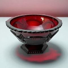 Vintage Avon ruby red glass compote with scalloped rim and pedestal base, featuring embossed Cape Cod pattern and rich crimson hue; a collectible 1970s–1990s candy dish styled for festive tables or vintage decor.