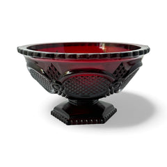 Vintage Avon ruby red glass compote with scalloped rim and pedestal base, featuring embossed Cape Cod pattern and rich crimson hue; a collectible 1970s–1990s candy dish styled for festive tables or vintage decor.