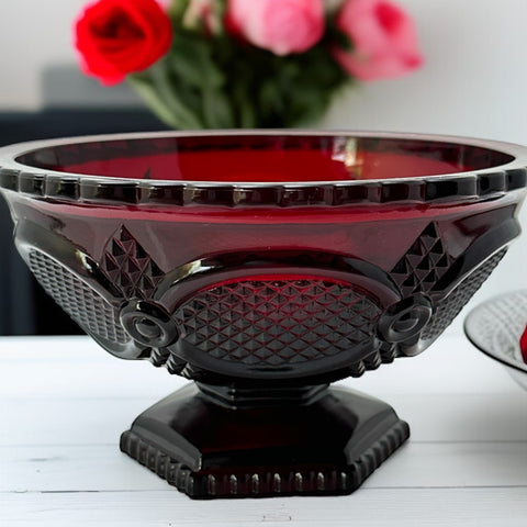 Vintage Avon ruby red glass compote with scalloped rim and pedestal base, featuring embossed Cape Cod pattern and rich crimson hue; a collectible 1970s–1990s candy dish styled for festive tables or vintage decor.