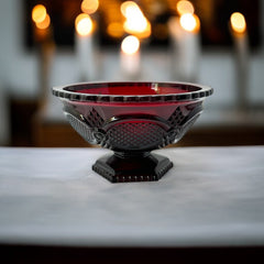 Vintage Avon ruby red glass compote with scalloped rim and pedestal base, featuring embossed Cape Cod pattern and rich crimson hue; a collectible 1970s–1990s candy dish styled for festive tables or vintage decor.