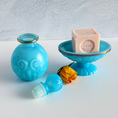 Vintage Avon turquoise opalite glass bottle and matching footed soap dish with gold‑tone trim.