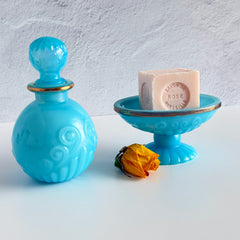 Vintage Avon turquoise opalite glass bottle and matching footed soap dish with gold‑tone trim.