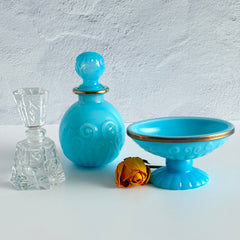 Vintage Avon turquoise opalite glass bottle and matching footed soap dish with gold‑tone trim.