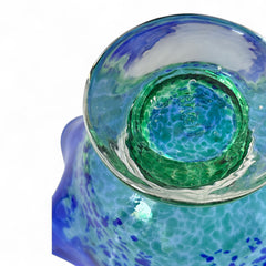 Signed BAGI art glass bowl with a footed base and wavy rim, featuring mottled blue and green swirls. The glass has a glossy finish and sculptural form, with vibrant oceanic and forest tones. Dimensions approximately 5–5½" tall and 7–8" wide.