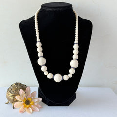 Vintage Banana Republic cream Lucite bead necklace with blue glass bead rondelles and gold‑tone clasp, signed BR.